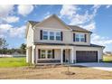 Two-story home featuring a covered front porch, dark shutters, and attached two-car garage at 300 Tuscany Cir, Princeton, NC 27569