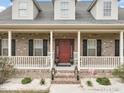 Inviting front porch with brick steps, white railings, and classic black shutters at 2674 Stanton Hill Rd, Cameron, NC 28326