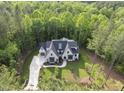 Aerial shot of an elegant two-story home surrounded by mature trees and lush landscaping at 7621 Falls Creek Ln, Raleigh, NC 27614