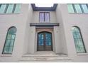 The beautiful custom front door is framed by arched windows and elegant grey brick at 865 Wimbleton Dr, Raleigh, NC 27609