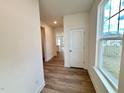Bright hallway with wood-look floors and a view into the kitchen at 48 Flowing River Rd # 35, Angier, NC 27501