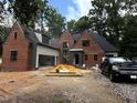 Charming brick two-story home with attached garage and lovely surrounding greenery at 708 Catawba St, Raleigh, NC 27609