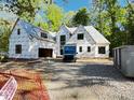 New construction home featuring windows, garage, and gravel driveway amid a wooded lot at 708 Catawba St, Raleigh, NC 27609