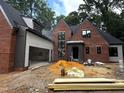 Beautiful brick two-story home with attached garage surrounded by lush trees at 708 Catawba St, Raleigh, NC 27609