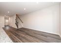 Spacious living room with hardwood floors, a staircase, and lots of natural light from the door in the background at 567 Marthas Vw Way, Wake Forest, NC 27587