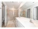 Well-lit main bathroom with a double sink vanity and glass shower doors at 569 Marthas Vw Way, Wake Forest, NC 27587