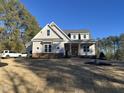 Two-story farmhouse with brick and board siding, welcoming porch at 3671 Graham Sherron Rd, Wake Forest, NC 27587