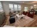 Open-concept living room with stylish seating, a contemporary coffee table, and abundant natural light at 115 Shooting Star Trl, Youngsville, NC 27596
