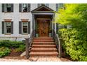 Elegant front entrance with a wood door, brick steps, and manicured greenery at 1800 Bay Meadow Ct, Raleigh, NC 27615