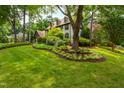 Beautifully landscaped front lawn with mature trees and flower beds enhancing the curb appeal of the home at 1800 Bay Meadow Ct, Raleigh, NC 27615