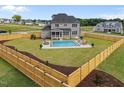 Expansive backyard features a fenced yard, well-maintained lawn, and a sparkling swimming pool with lounge area at 25 Cotton Fields Ln # 29, Fuquay Varina, NC 27526