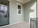Charming covered porch with gray siding, white trim and a gray front door and black iron railing at 205 Wash Hollow Dr, Wendell, NC 27591