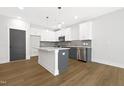 Modern kitchen with white cabinets, gray island, stainless appliances and stylish tile backsplash at 320 Church St, Morrisville, NC 27560