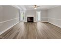 Spacious living room with fireplace, neutral walls, wood-look floors, and doors to the backyard at 1432 Quarter Pt, Raleigh, NC 27615