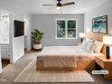 Staged primary bedroom featuring a large window, ceiling fan, and closet at 1432 Quarter Pt, Raleigh, NC 27615