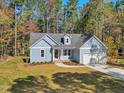 Beautiful single-story home with light blue siding, charming dormer, and mature tree landscaping at 146 Wood Wedge, Sanford, NC 27332