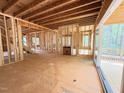 Open-concept living room under construction showing exposed framing, large windows, and sliding glass doors at 111 Gaines Trail, Pittsboro, NC 27312