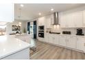 Bright kitchen featuring white cabinets, stainless steel appliances, and modern lighting at 136 Newport Lndg, Garner, NC 27529