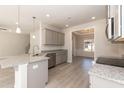 Open kitchen with gray cabinetry, stainless steel appliances, and a granite island at 136 Newport Lndg, Garner, NC 27529