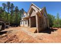 New two story home featuring brick and siding exterior, a covered porch, and a partially completed yard at 162 Gaines Trail, Pittsboro, NC 27312