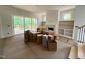 Bright living room with built-in shelves, a fireplace, and sliding glass doors to a deck at 162 Gaines Trail, Pittsboro, NC 27312