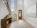 Bright foyer with wooden floors, stairway, and a front door that allows natural light at 5812 Shawood Dr, Raleigh, NC 27609