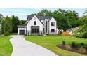 Landscaped two-story home features a long driveway leading to an attached garage at 5812 Shawood Dr, Raleigh, NC 27609