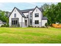 Stunning two-story home with a lush green lawn and modern exterior design elements at 5812 Shawood Dr, Raleigh, NC 27609