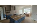 Bright kitchen featuring white cabinets, a central island, and a view from many windows at 5812 Shawood Dr, Raleigh, NC 27609