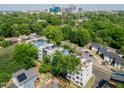Aerial view of modern townhomes surrounded by lush greenery, showcasing urban living near the city skyline at 600 Rocky Knob Ct, Raleigh, NC 27601
