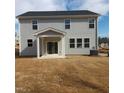 Rear exterior featuring light gray siding, covered patio, and sliding glass doors to the grassy backyard at 39 Longdale Dr, Graham, NC 27253