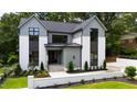 Home exterior with a combination of gray siding, white accents, and manicured lawn at 5208 Knollwood Rd, Raleigh, NC 27609