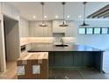 Modern kitchen featuring an island, stylish pendant lighting, and pristine marble countertops at 5208 Knollwood Rd, Raleigh, NC 27609