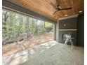 Covered outdoor living space with stone floors, a wood ceiling, and a cozy fireplace, perfect for entertaining at 5208 Knollwood Rd, Raleigh, NC 27609