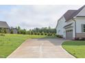 Long driveway leading to a modern home with ample parking space and well-maintained landscaping at 55 Harvest View Way, Franklinton, NC 27525