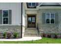 Elegant front entry with stone steps, double doors, and manicured landscaping at 55 Harvest View Way, Franklinton, NC 27525