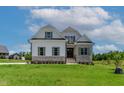 Charming two-story home showcasing a lush green lawn and classic architectural details at 55 Harvest View Way, Franklinton, NC 27525