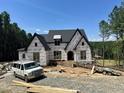 New construction exterior showcasing the home's architectural design, windows, and the surrounding wooded landscape at 37 Green Turtle Ln, Pittsboro, NC 27312