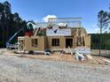 New home under construction with framing, sheathing, and roof trusses on a sunny day at 37 Green Turtle Ln, Pittsboro, NC 27312