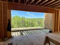 View of the construction and the beautiful wooded landscape through the window of a new home at 37 Green Turtle Ln, Pittsboro, NC 27312