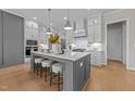 Bright kitchen features large island with seating and a gas range with modern stainless steel hood at 820 Willow Tower Ct # 153, Rolesville, NC 27571