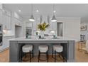 Beautiful kitchen island with white countertops, pendant lighting, and seating for three people at 820 Willow Tower Ct # 153, Rolesville, NC 27571