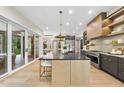Bright modern kitchen features hardwood floors, stainless appliances, and sliding doors to the backyard at 4123 Rockingham Dr, Raleigh, NC 27609