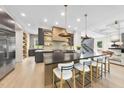 Open concept kitchen with a large island, barstool seating, stainless appliances, and custom cabinets at 4123 Rockingham Dr, Raleigh, NC 27609