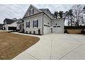 Attractive house featuring a spacious three-car garage and concrete driveway at 165 Inspiration Way, Fuquay Varina, NC 27526