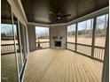 Cozy sunroom with fireplace, wood floors, and serene outdoor views at 165 Inspiration Way, Fuquay Varina, NC 27526