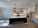 Spacious kitchen with large island, stainless steel appliances, and white cabinets at 183 Inspiration Way, Fuquay Varina, NC 27526