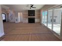 Open living room featuring a fireplace, built-in shelving, and sliding glass doors at 183 Inspiration Way, Fuquay Varina, NC 27526