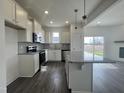 Bright kitchen featuring stainless appliances, ample counter space, hardwood floor, and a central kitchen island at 189 Waterwheel Dr, Selma, NC 27576