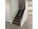 Carpeted staircase features modern wood and black iron railing leading to upper level at 60 Lemon Drop Ln, Franklinton, NC 27525